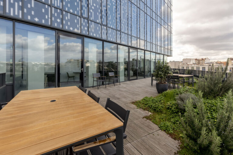 terrasse d'immeuble avec tables, chaises et végétations